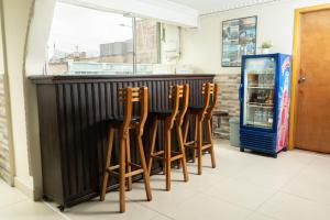 a bar with a row of wooden stools in a restaurant at Hotel Juanambu in Pasto