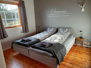 uma sala de estar com um sofá e 2 camas em Cosy chalet, 100m2 with fjordview! em Lauvstad