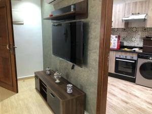 cocina con TV de pantalla plana grande en la pared en Seaside Serenity Retreat 2BR - Exclusively for Families, en Ras El Ma