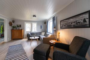 un soggiorno con divano e 2 sedie di Cozy House By The Fjord In The Heart Of Lofoten a Reine