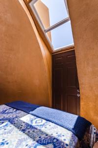 a small bedroom with a bed and a window at Hostal Cosmo Elqui in Rivadavia