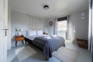 um quarto com uma cama e uma janela em Cozy House By The Fjord In The Heart Of Lofoten em Reine