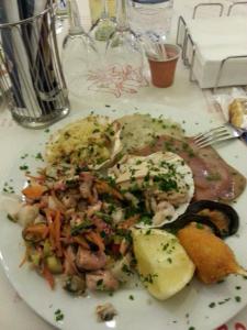 une assiette blanche de nourriture sur une table dans l'établissement Hotel Giulio Cesare, à Cattolica