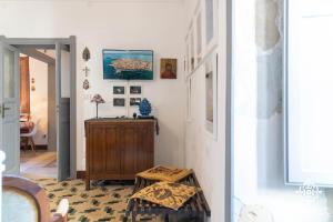 una sala de estar con un armario de madera y una mesa. en Casa Sophia, en Siracusa