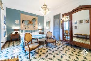 a bedroom with a bed and chairs and a mirror at Casa Sophia in Siracusa