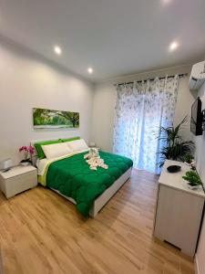 um quarto com uma cama verde e uma janela em Kenzia Apartment em Trapani