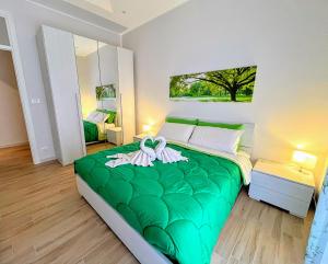 um quarto com uma cama verde e toalhas em Kenzia Apartment em Trapani