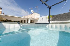 a swimming pool with blue water in front of a building at YourHouse Es Pla Cycling House in Maria de la Salut