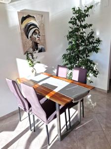 een eetkamer met een houten tafel en paarse stoelen bij Arenal in Jávea