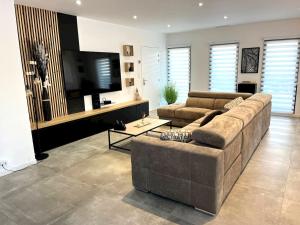 a living room with two couches and a flat screen tv at Villa accueillante à Millas avec piscine privée et jacuzzi in Millas