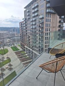 Un balcón con sillas y vista a una ciudad. en Crown Apartments - BW Sole, en Belgrado
