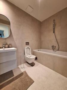 Un baño con inodoro, bañera y lavabo. en Crown Apartments - BW Sole, en Belgrado