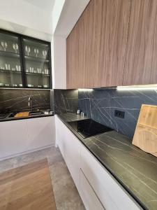 a kitchen with black counter tops and wooden cabinets at Crown Apartments in Belgrade
