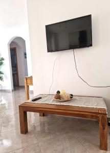a living room with a table and a television on a wall at Arenal in Jávea