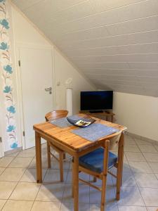 comedor con mesa de madera y TV en Appartment Haus Müller, en Kelberg