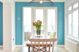 a dining room with a table with flowers in a vase at Princes Esplanade in Cowes