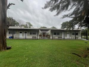 a building with a large yard in front of it at Finca Las Acacias in Marcos Paz