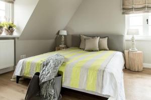 a bedroom with a bed with a yellow and gray comforter at Home-by-Sea in Westerland (Sylt)