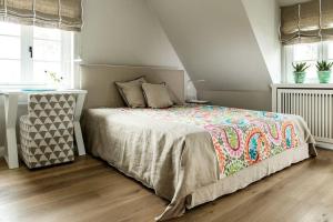 a bedroom with a bed with a colorful blanket on it at Home-by-Sea in Westerland (Sylt)