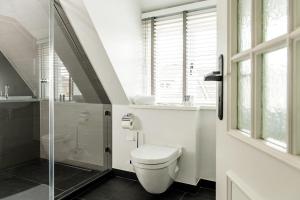 a bathroom with a toilet and a glass shower at Home-by-Sea in Westerland (Sylt)