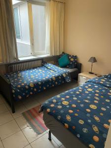 1 Schlafzimmer mit 2 Betten, einem Sofa und einem Fenster in der Unterkunft Appartement 2 chambres spacieux pour 4 personnes in Knokke-Heist