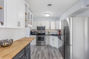 a kitchen with white cabinets and a stainless steel refrigerator at Sofia's Square Unit 2 in Omaha