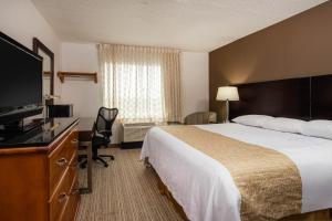 a hotel room with a bed and a flat screen tv at Travelodge by Wyndham Fort Wayne North in Fort Wayne