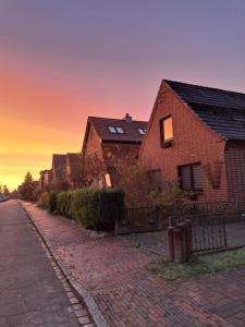 a row of houses on a brick street at sunset at Ferienwohnung Casa Capurso in Glückstadt