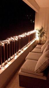 a row of pillows on a balcony with lights at Appartement Cosy Luxury with Lake in Brunoy