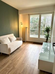 a living room with a couch and a window at Appartement Cosy Luxury with Lake in Brunoy