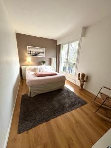a bedroom with a bed and a large window at Appartement Cosy Luxury with Lake in Brunoy
