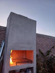 un horno de piedra con un fuego dentro de él en Alojamiento San Juan, en Trinidad