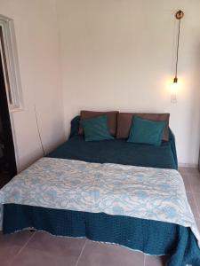 Un dormitorio con una cama con almohadas azules. en Alojamiento San Juan, en Trinidad