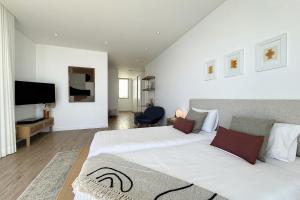 a bedroom with two beds and a flat screen tv at Villa OceanAIR by LovelyStay in Prazeres +49 photos