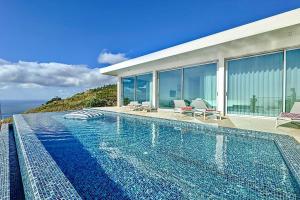 a swimming pool in front of a house at Villa OceanAIR by LovelyStay in Prazeres