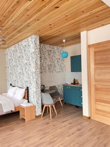 a bedroom with a bed and a table and a kitchen at Apart-Hotel Seti in Mestia
