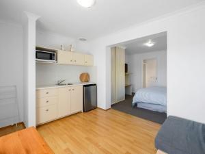 um quarto com uma cozinha e uma cama num quarto em Kalisti Suites - Fira Suite em Port Sorell