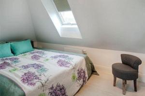 een slaapkamer met een bed en een stoel bij La-Mer-4 in Westerland