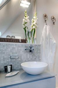 een badkamer met een witte wastafel en een spiegel bij La-Mer-4 in Westerland