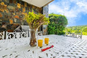 einen weißen Tisch mit zwei Gläsern Orangensaft in der Unterkunft Baluwatu 10, Zimbali Estate in Ballito