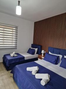 duas camas num quarto com lençóis azuis e brancos em Villa Korado em Saranda
