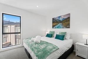 a bedroom with a large bed and a window at Clutha River Haven in Albert Town