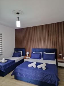um quarto com 2 camas com lençóis azuis e brancos em Villa Korado em Saranda