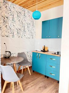 a kitchen with blue cabinets and a table at Apart-Hotel Seti in Mestia