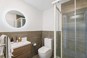 a bathroom with a toilet and a glass shower at Clutha River Haven in Albert Town