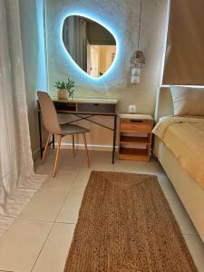 a bedroom with a desk and a bed with a mirror at Filoxenia City Apartment in Zakynthos