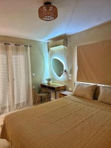 a bedroom with a large bed and a desk at Filoxenia City Apartment in Zakynthos