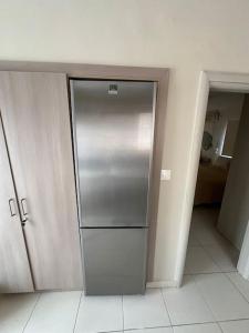 a hallway with a stainless steel refrigerator in a room at Filoxenia City Apartment in Zakynthos