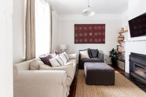uma sala de estar com dois sofás e uma lareira em Galvin Town Cottage, convenient to CBD em Kings Park