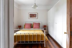 um quarto com uma cama com duas almofadas vermelhas em Galvin Town Cottage, convenient to CBD em Kings Park
